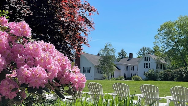 A garden with pink flowers and white chairs. - Warren Conference Center and Inn (Ashland)