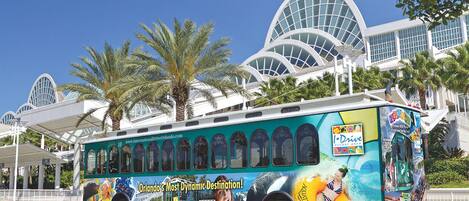 A bus with a large advertisement for Orlando's I-Ride, featuring palm trees and a tropical theme.