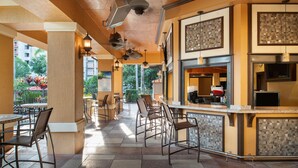 An indoor dining area with multiple tables and chairs, a bar counter, and hanging pendant lights. - Floridays Resort Orlando (Orlando)