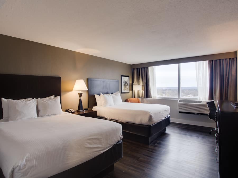 Habitación, 2 camas Queen size | Área de sala de estar | Televisión de pantalla plana de 49 pulgadas con canales vía satélite