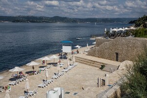 Playa privada, sillas reclinables de playa, sombrillas