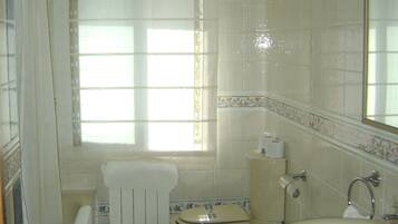 Un baño con inodoro, bidé y lavabo.
