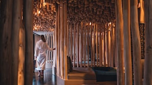 A spa area with wooden slats and a person in a robe.
