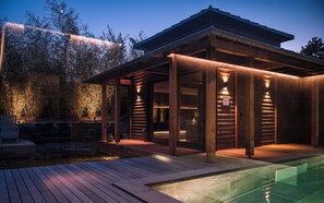 Un área de piscina exterior moderna con terraza de madera y zona de estar techada.