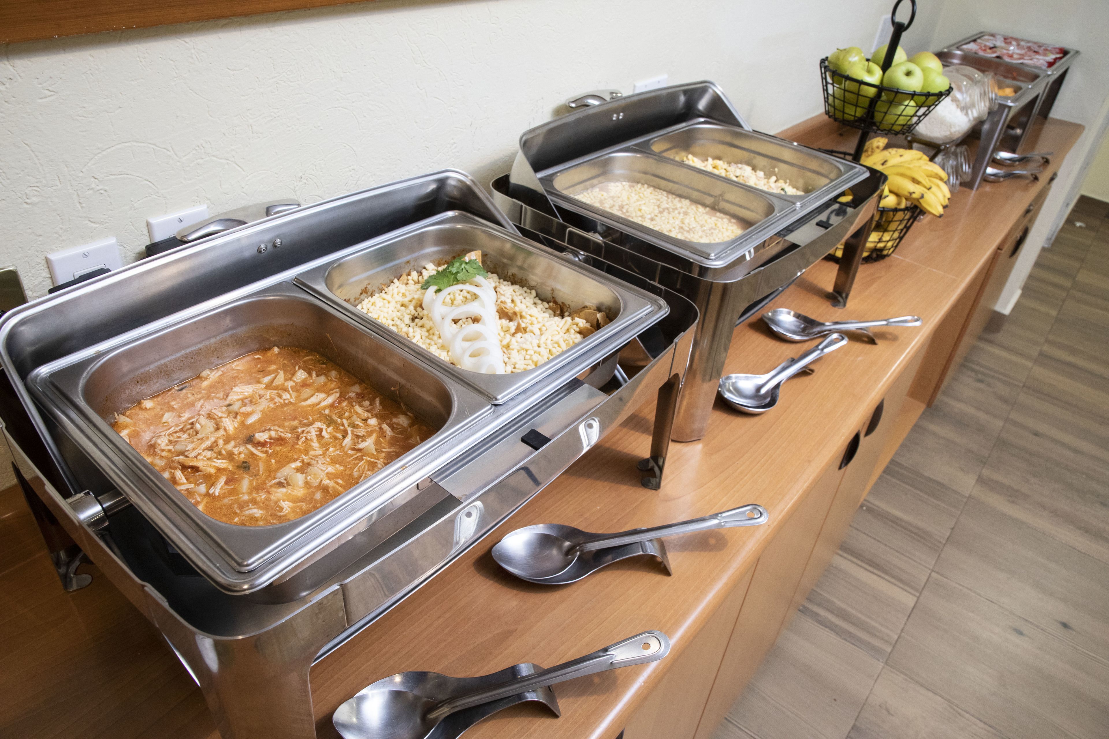 A buffet with various food options and utensils.