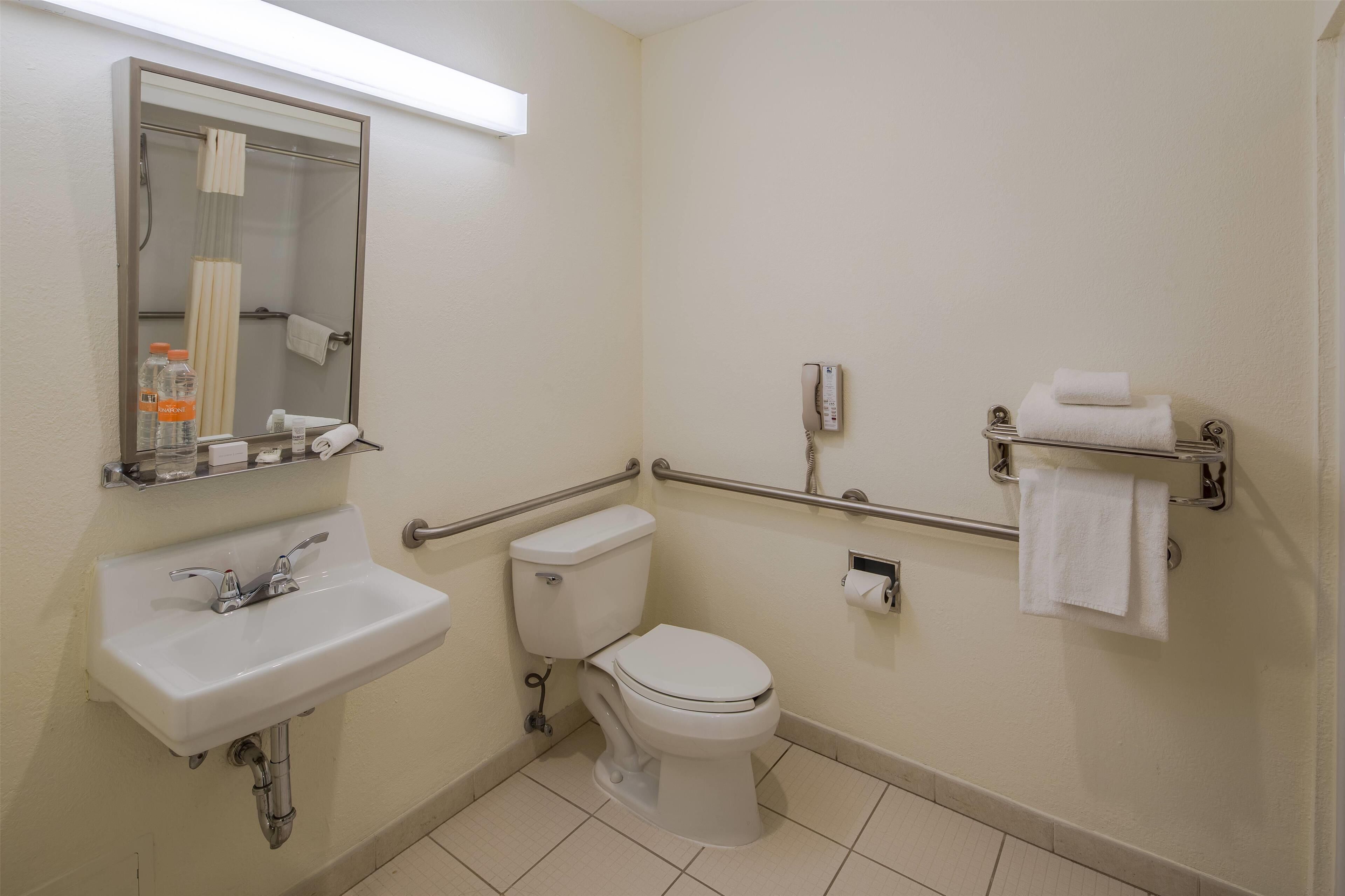 Un baño pequeño y limpio, con lavamanos, inodoro y espejo.