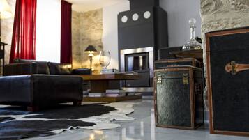 Una sala de estar con chimenea, sofá de cuero y baúles antiguos.