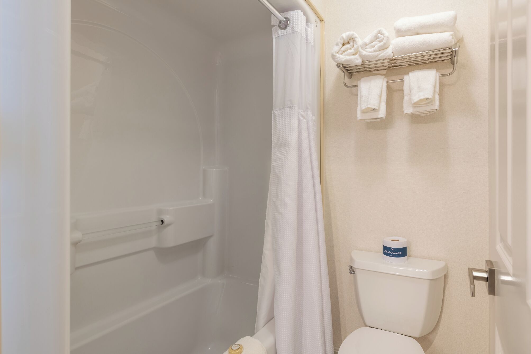 A bathroom with a shower, toilet, and towel rack.