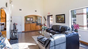 A spacious lobby with a leather sofa, a reception desk, and a large window offering a view of the outside. - Rodeway Inn & Suites Humble IAH (Humble)