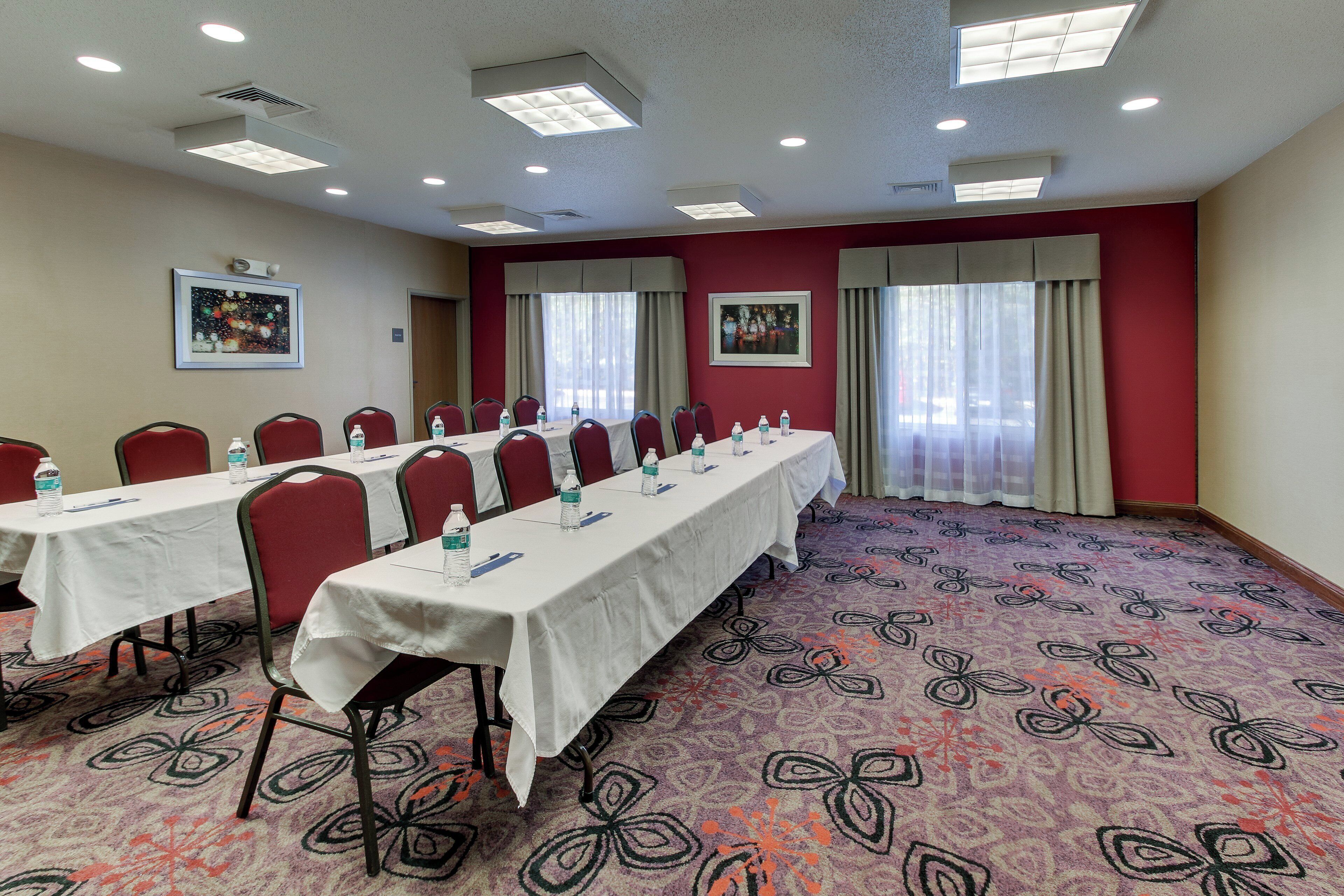 A conference room with long tables, chairs, and water bottles.