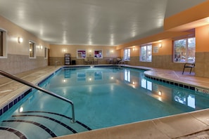 An indoor swimming pool with a clear water surface, a pool ladder, and a 'No Diving Allowed' sign.