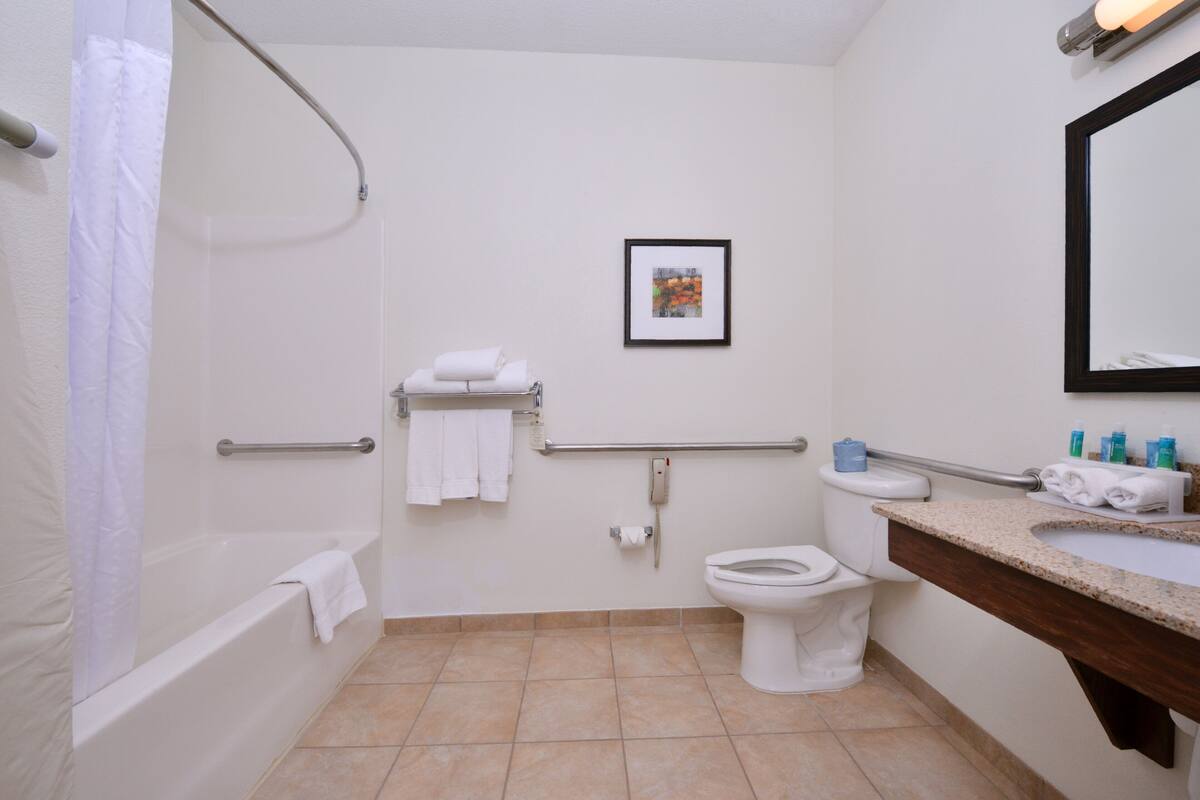 A bathroom with a bathtub, toilet, and sink.