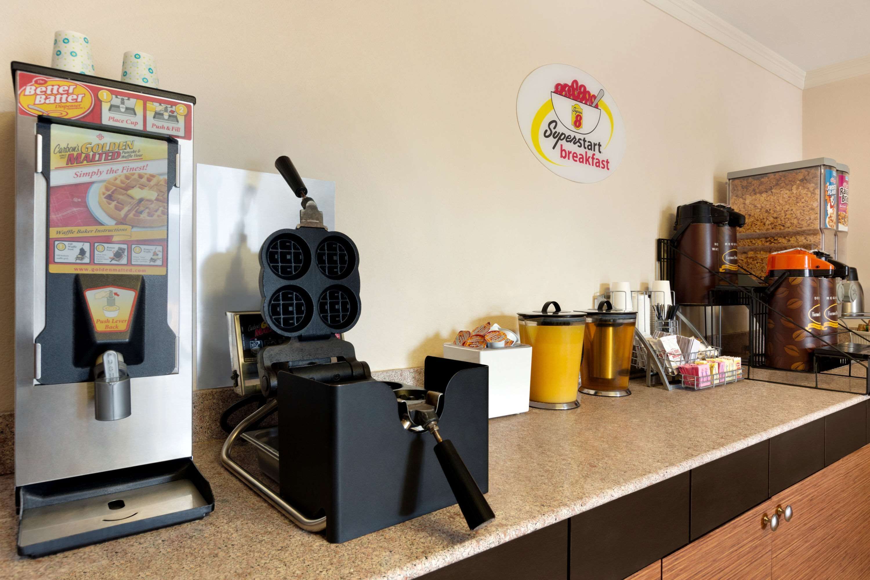 Eine Küchenzeile mit einem Waffeleisen, einer Kaffeemaschine und einer Kaffeemühle.