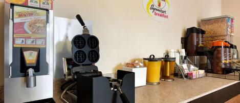 Eine Küchenzeile mit einem Waffeleisen, einer Kaffeemaschine und einer Kaffeemühle.