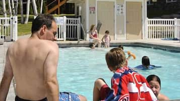 Guests can enjoy a refreshing swim in the pool surrounded by a secure fence and shaded by trees.