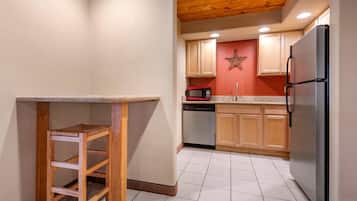 Una cocina con armarios de madera, un refrigerador de acero inoxidable, un microondas y un lavavajillas.