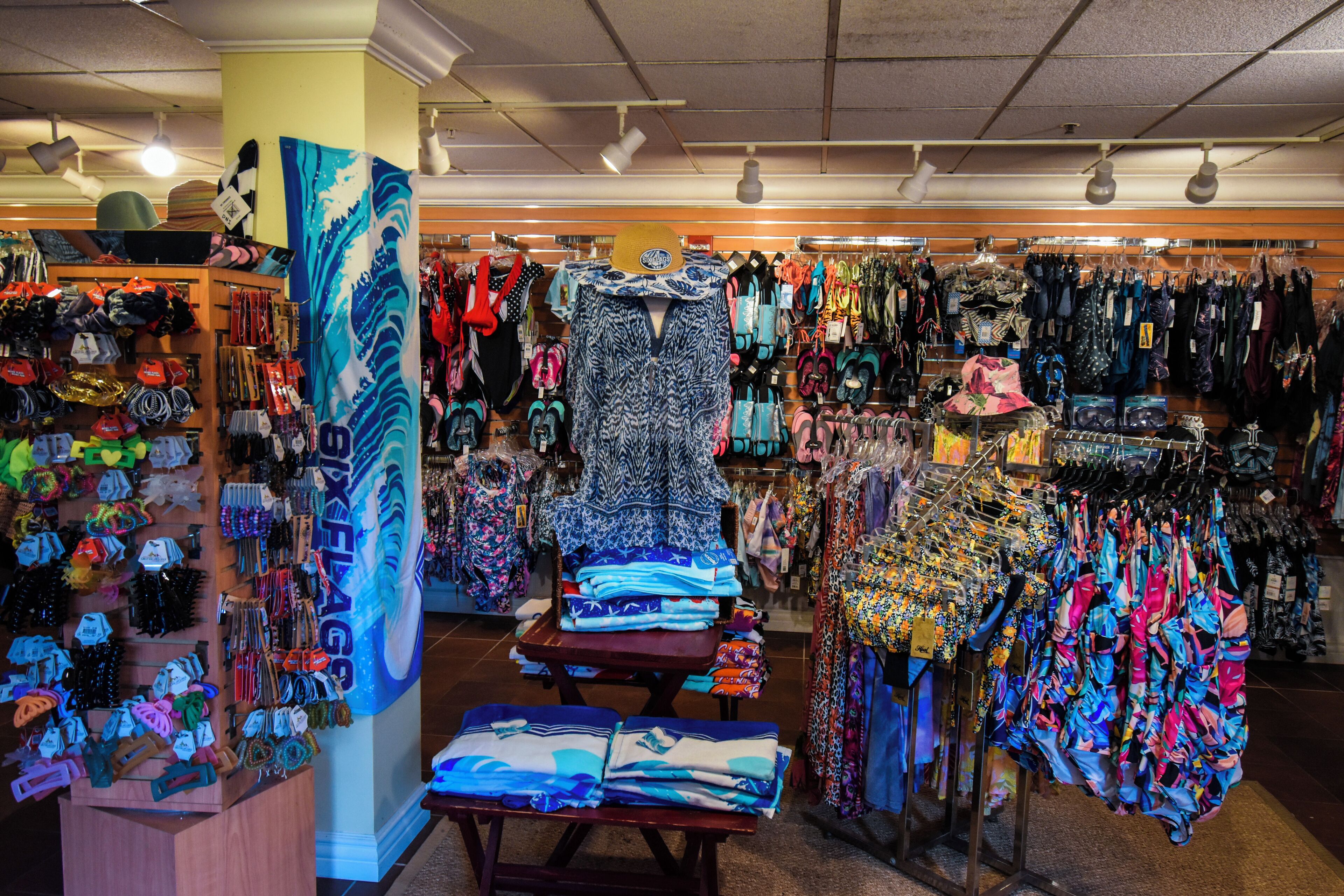A store with various clothing items, accessories, and folded textiles on display.