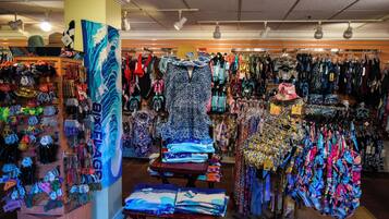 A store with various clothing items, accessories, and folded textiles on display.