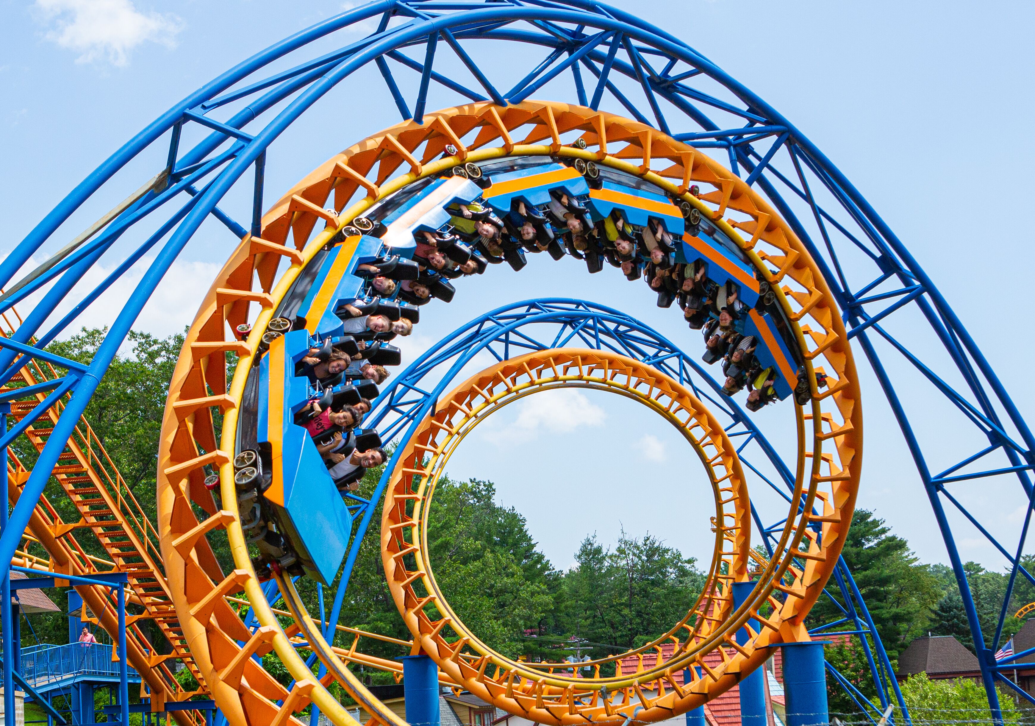 A roller coaster with multiple loops and a clear sky in the background.