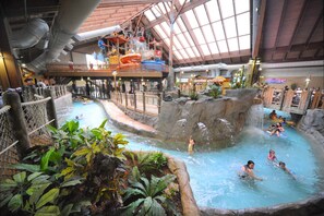 An indoor water park with multiple pools, slides, and a high platform. - Great Escape Lodge & Indoor Waterpark (Queensbury)