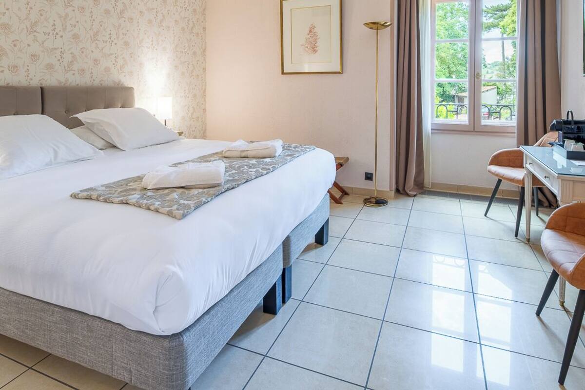 Una habitación de hotel con una cama, un escritorio y una silla.