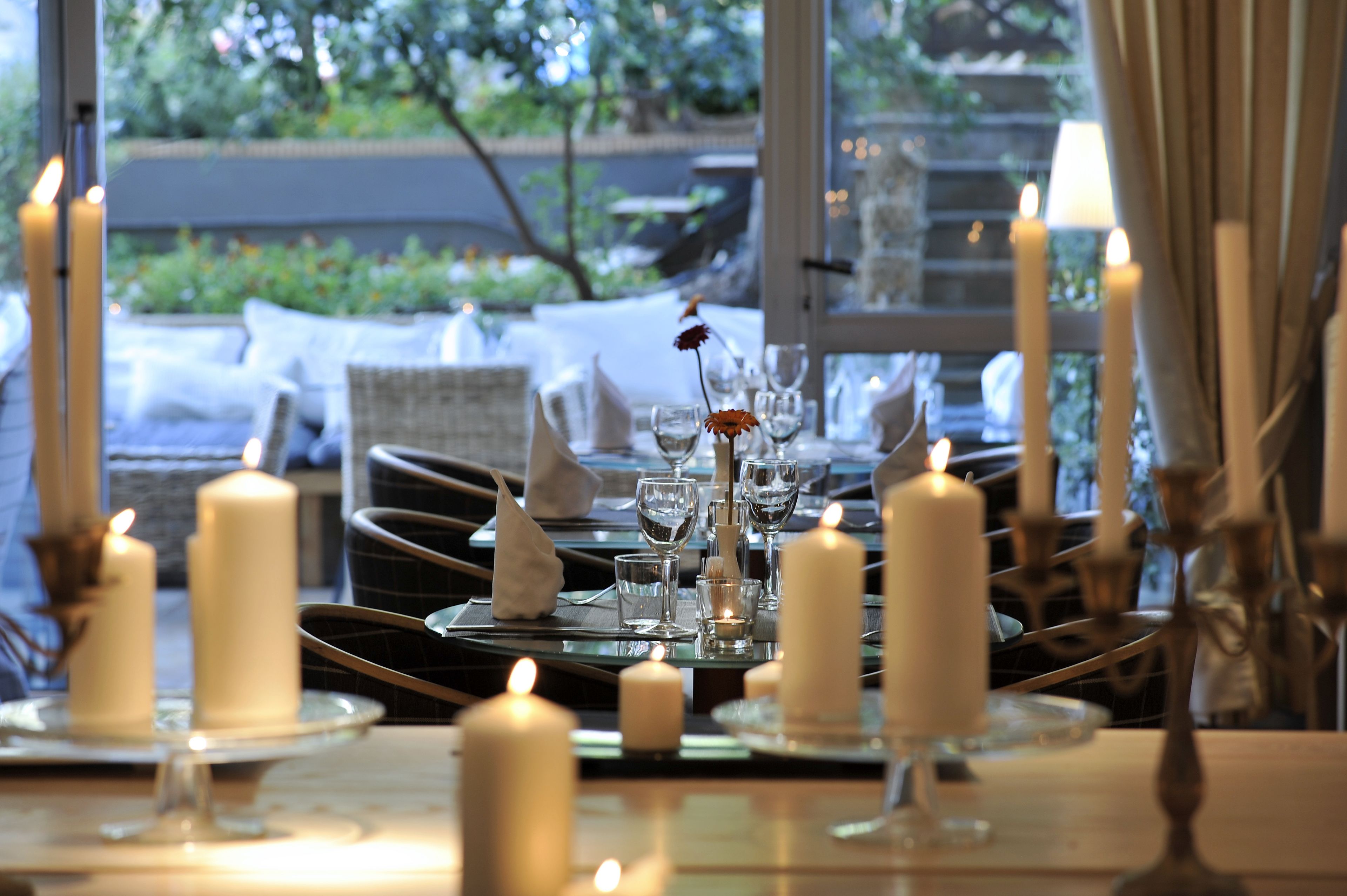 A table set for dining with candles, glasses, and napkins.