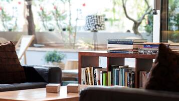 A cozy living room with a bookshelf, a coffee table, and a couch.