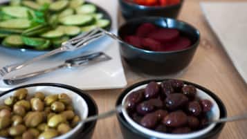 Ett bord med olika sorters mat, inklusive oliver, gurkor och rödbetor.