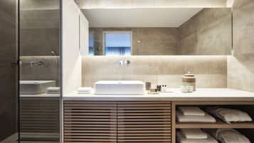 Un baño moderno con un espejo grande, una bañera y un tocador con lavamanos.