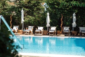 A poolside area with lounge chairs and umbrellas.