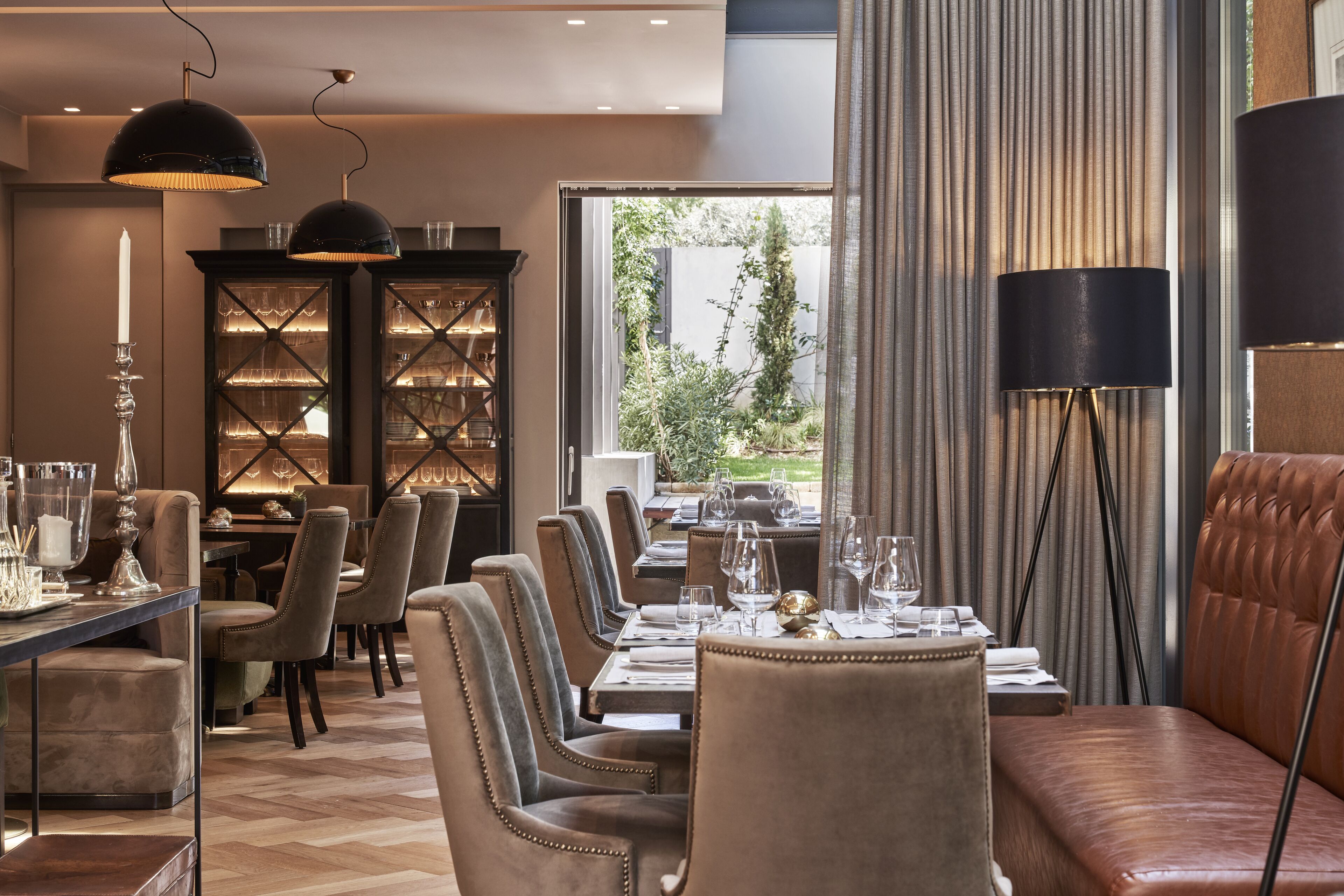 A dining area with a long table set for a meal, surrounded by upholstered chairs.