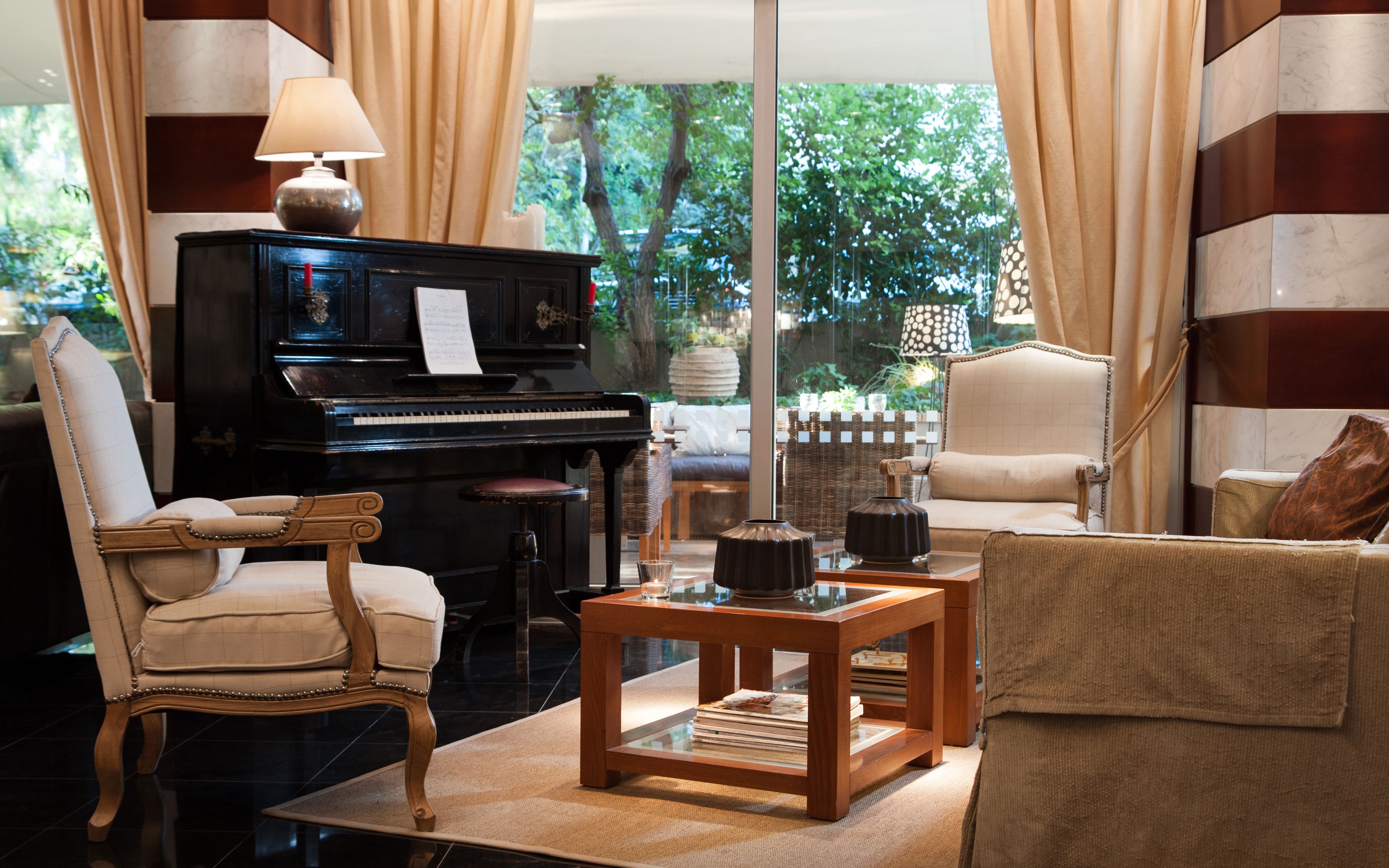 Un salón con un piano de cola, una mesa de centro de madera y un sofá cómodo.