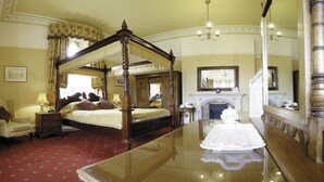 A four-poster bed with a canopy, a mirror, a fireplace, and a chandelier. - Cotford Hotel (Malvern)