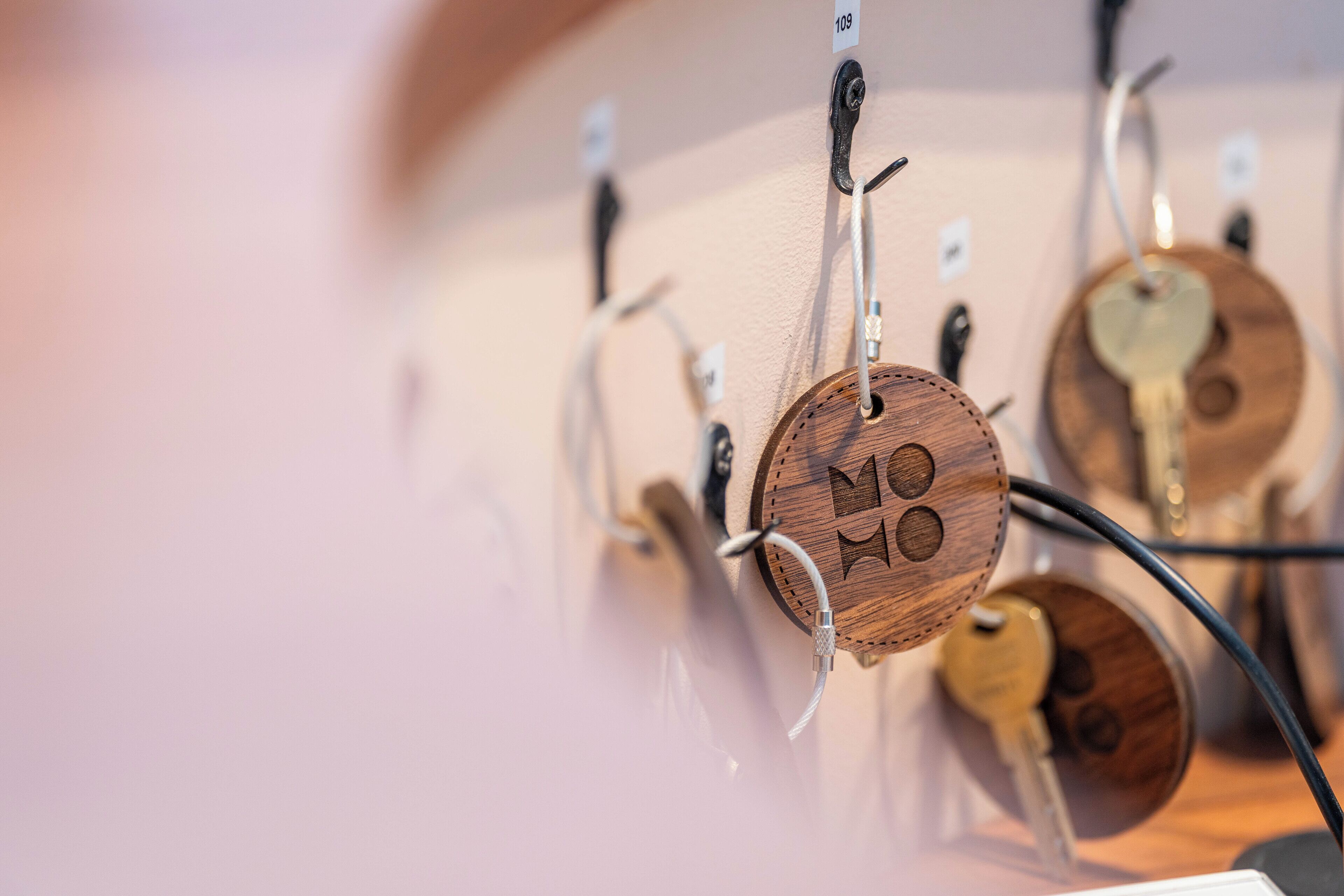 A wall with multiple keys hanging on hooks, each labeled with a number.