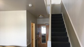 A hallway with a staircase leading to an upper floor. - Moreton Park Lodge (Wrexham)