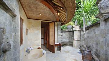 Relax in a, luxurious space with a bathtub and wooden stool.