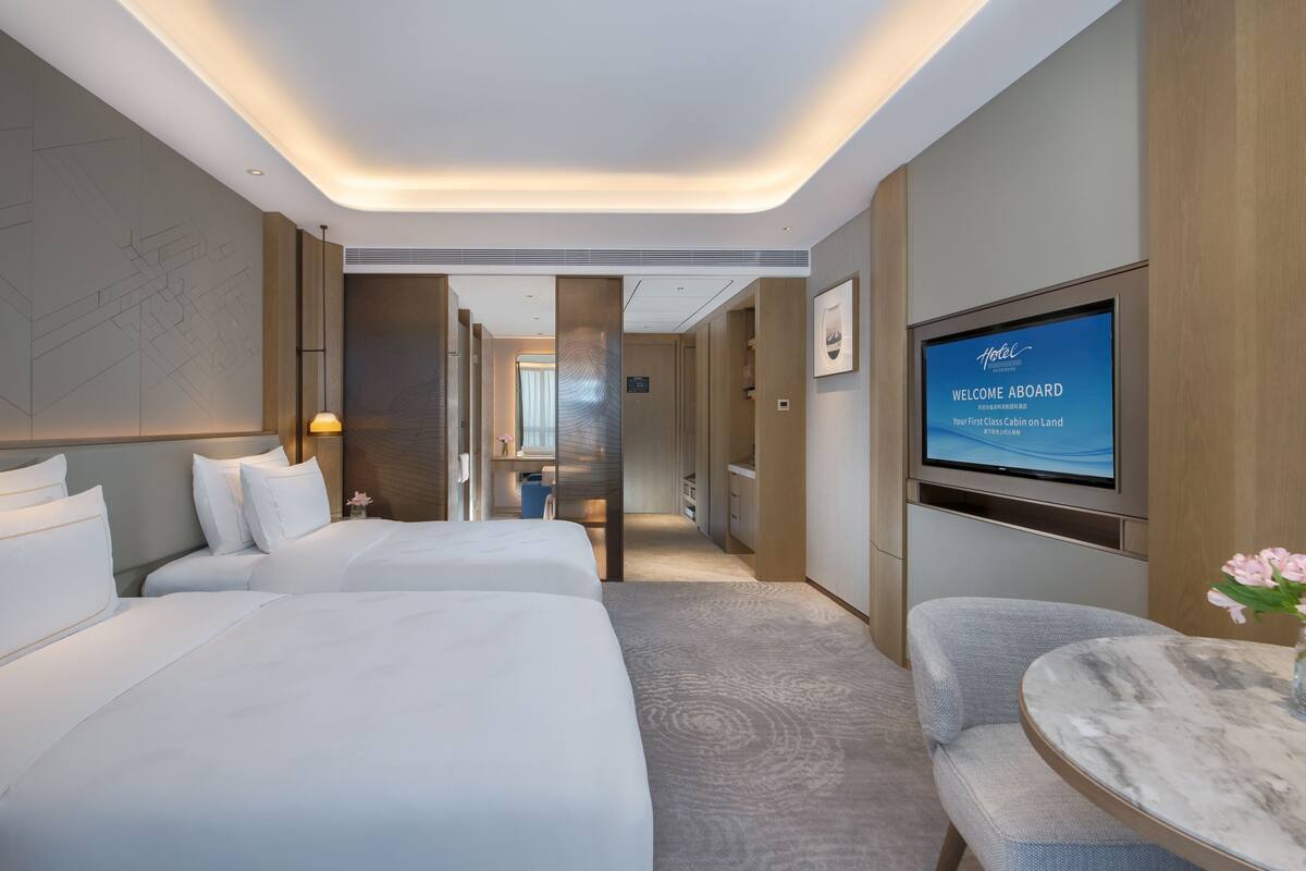Une chambre d’hôtel moderne dotée d’un grand lit, d’une télévision et d’un coin salon.