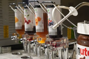 A juice dispenser with multiple spouts, each labeled with different fruit flavors.