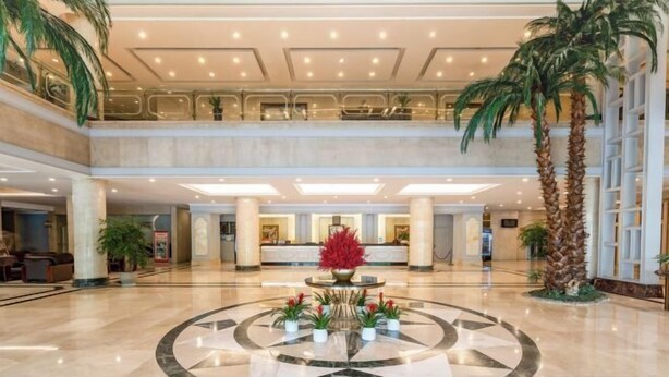 A spacious lobby with a central circular area featuring a decorative fountain and potted plants. - Ningbo Zoyi Grand Hotel (Ningbo)