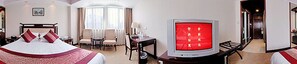Una habitación de hotel con una cama, un escritorio, un televisor y una zona de estar.