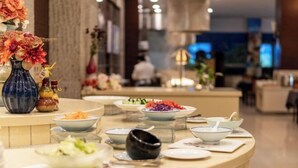 A buffet setup with various dishes and a decorative vase. - Ningbo Zoyi Grand Hotel (Ningbo)