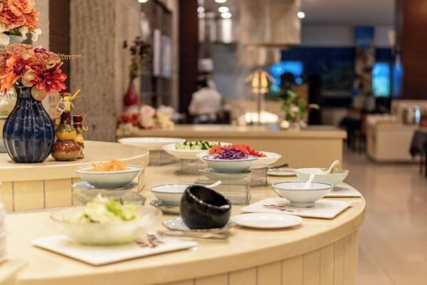 A buffet setup with various dishes and a decorative vase. - Ningbo Zoyi Grand Hotel (Ningbo)