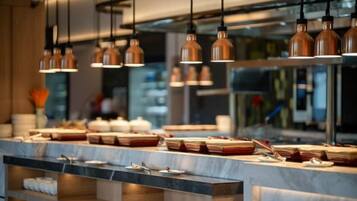 Una cocina moderna con iluminación colgante, encimera de mármol y diverso menaje de cocina.