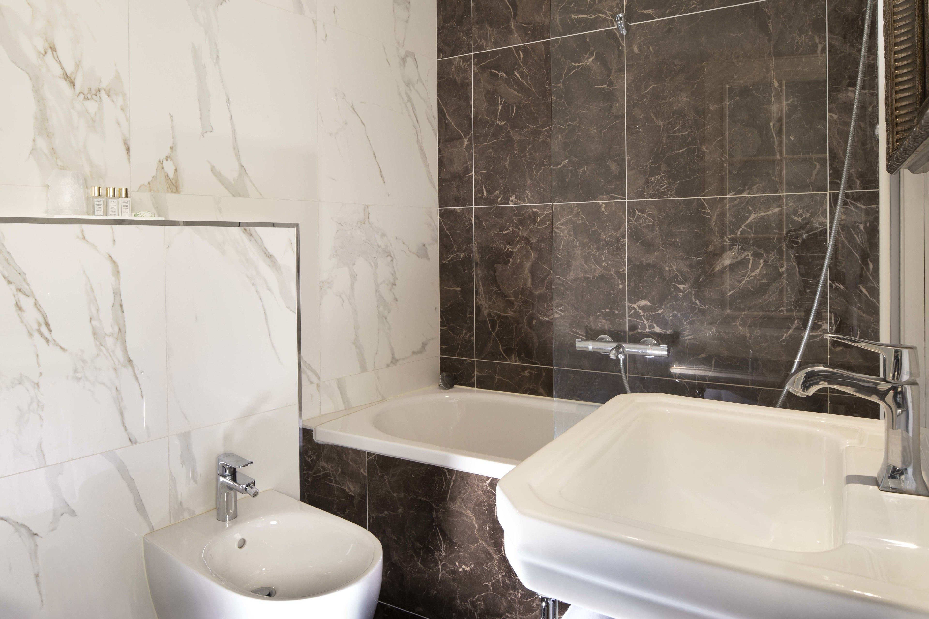 A bathroom with a bidet, a bathtub, and a sink.