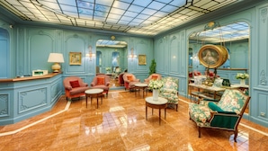 A luxurious room with a marble floor, elegant furniture, and a large mirror.