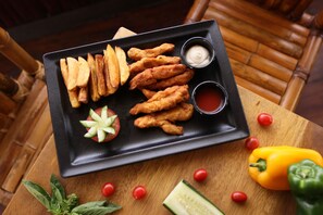 Frukost och lunch serveras, med utsikt mot trädgården 