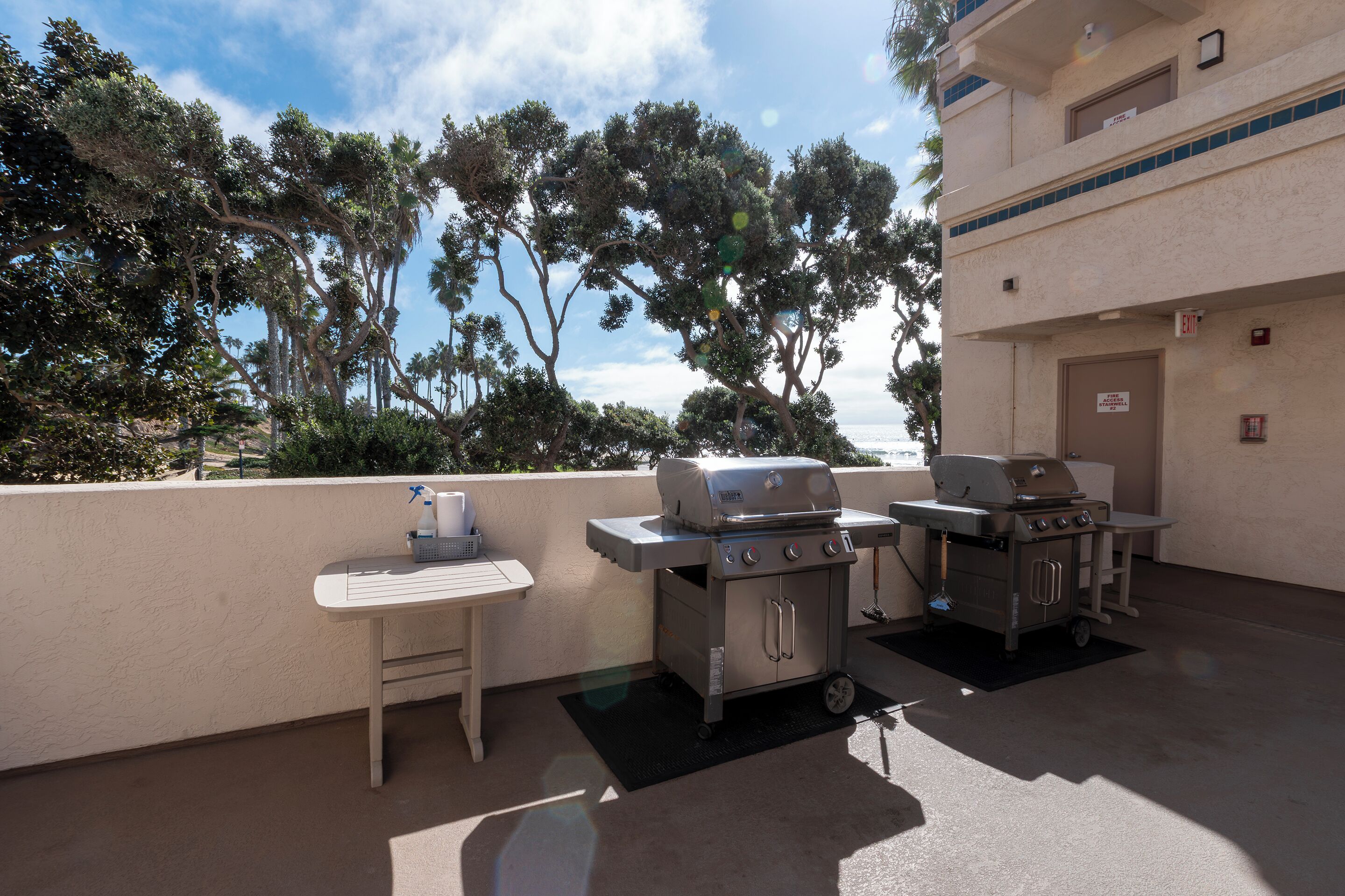 An outdoor patio with a grill station, a table, and a chair.