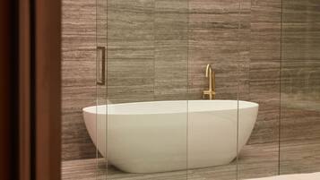A modern bathroom with a freestanding bathtub, a gold faucet, and a wooden floor.