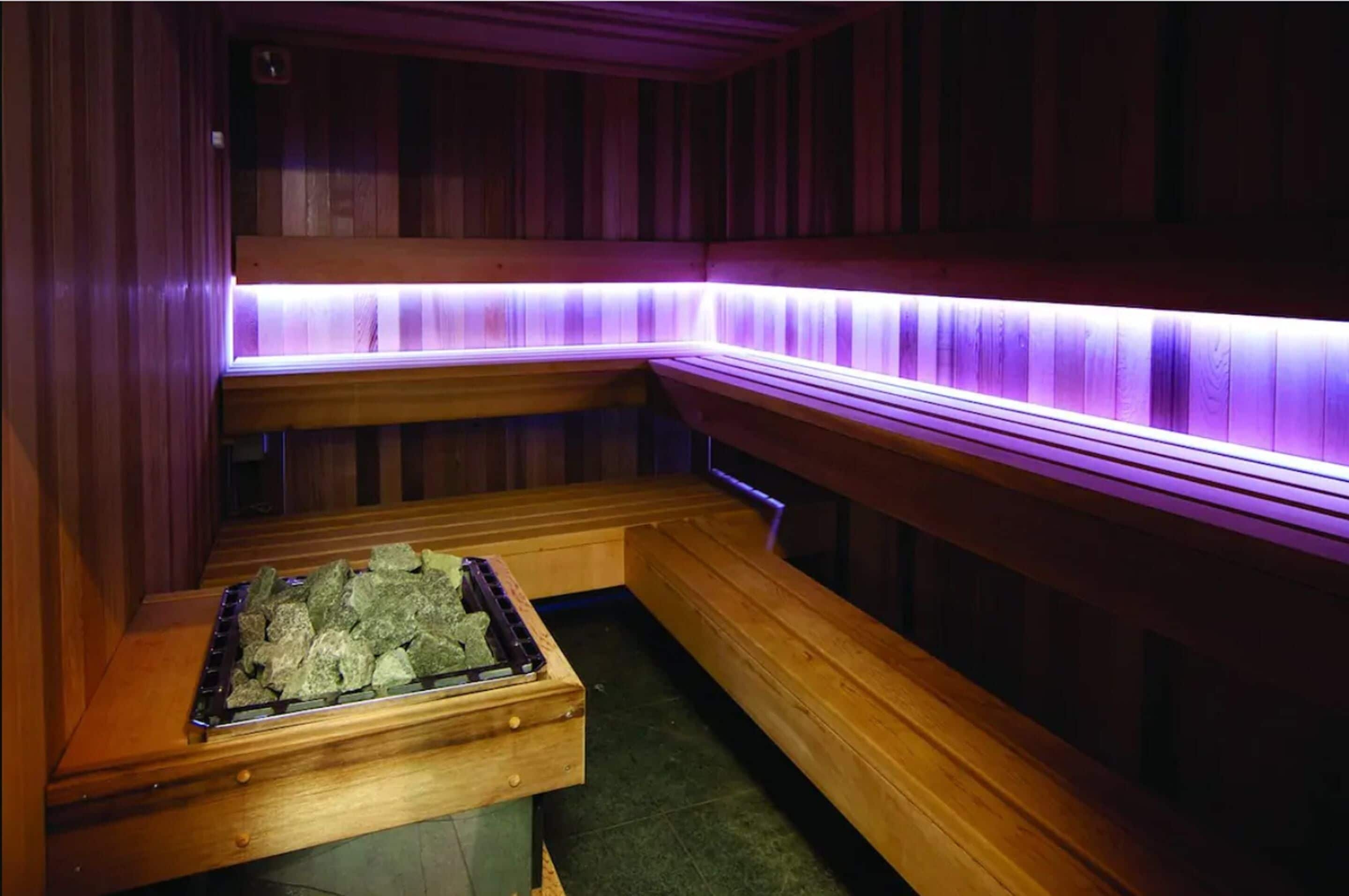 Una sauna con bancos de madera y un calentador de piedra.