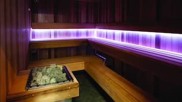 Una sauna con bancos de madera y un calentador de piedra.